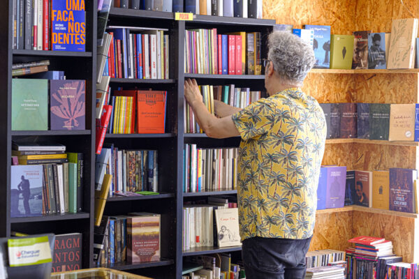 Um homem procura um livre nas estantes da Livraria Tigre de Papoel em Lisboa